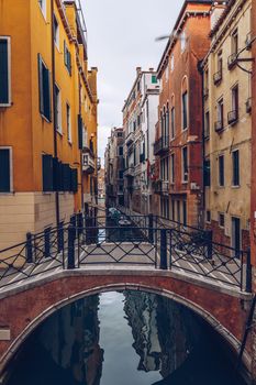 View of the street canal in Venice, Italy. Colorful facades of old Venice houses. Venice is a popular tourist destination of Europe. Venice, Italy.