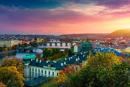 Autumn view to Charles bridge on Vltava river in Prague, Czech Republic. Autumn view to Charles Bridge, Prague old town and Vltava river from Letna park (Letenske sady) at sunset with colorful sky.