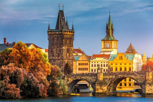Autumn view to Charles bridge on Vltava river in Prague, Czech Republic. Autumn view to Charles Bridge, Prague old town and Vltava river. Czechia. Scenic autumn view of the Old Town with red foliage.