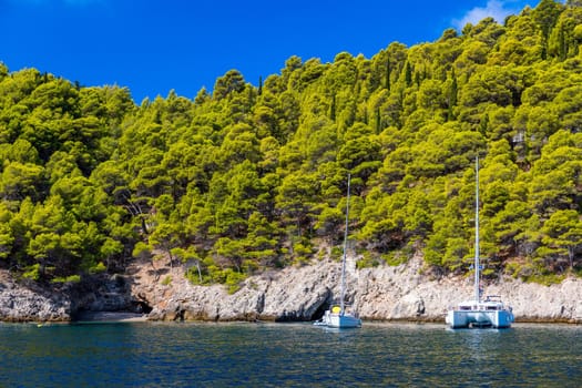 White sail boat isolated in blue sea water. Sailboat in the sea in the sunlight, luxury summer adventure, active vacation in Mediterranean sea. Yacht sailing on opened sea. Sailing boat. 