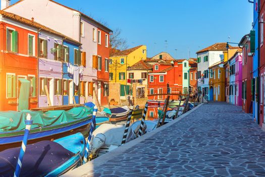 Street with colorful buildings in Burano island, Venice, Italy. Architecture and landmarks of Burano, Venice postcard. Scenic canal and colorful architecture in Burano island near Venice, Italy
