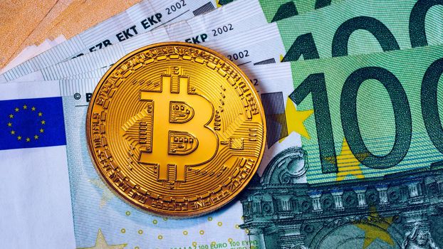 Bitcoin cryptocurrency (crypto currency) over Euro money. Golden Bitcoin symbol. Bitcoin (BTC) cryptocurrency.