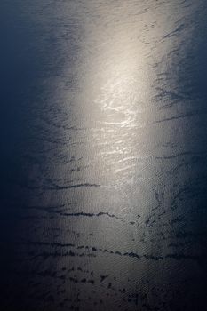 Sunlight twinkling and reflecting off sea water. Sparkles on water. Sun reflecting on the ocean surface, view from the plane, concept of travel. 