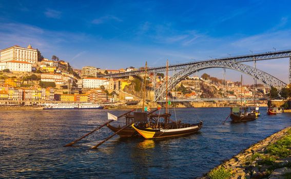 Port wine boats at the waterfront with Dom Luis bridge and the old town on the Douro River in Ribeira in the city centre of Porto in Porugal in Europe. Portugal, Porto