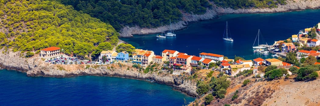 Assos village in Kefalonia, Greece. Turquoise colored bay in Mediterranean sea with beautiful colorful houses in Assos village in Kefalonia, Greece, Ionian island, Cephalonia, Assos village.