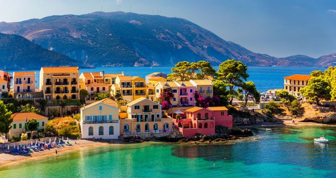 Assos village in Kefalonia, Greece. Turquoise colored bay in Mediterranean sea with beautiful colorful houses in Assos village in Kefalonia, Greece, Ionian island, Cephalonia, Assos village.