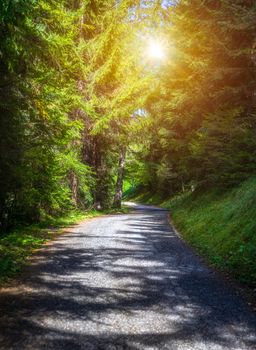 Mountain road. Landscape with rocks, sunny sky with clouds and beautiful asphalt road in the evening in summer. Vintage toning. Travel background. Highway in mountains.  