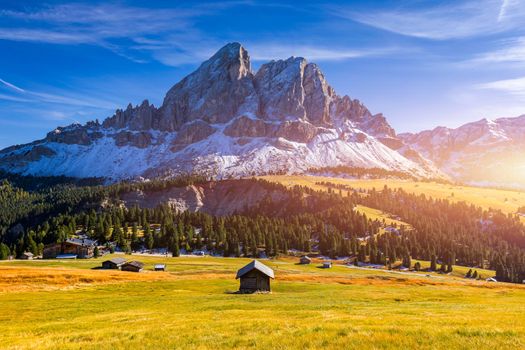 Stunning view of Peitlerkofel mountain from Passo delle Erbe in Dolomites, Italy. View of Sass de Putia (Peitlerkofel) at Passo delle Erbe, with wooden farm houses, Dolomites, South Tyrol, Italy.