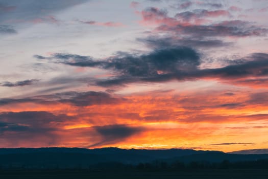 Natural Sunset Sunrise Over Field Or Meadow. Bright Dramatic Sky And Dark Ground. Countryside Landscape Under Scenic Colorful Sky At Sunset Dawn Sunrise. Sun Over Skyline, Horizon. Warm Colours.