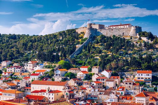 Panoramic view of Hvar town with lots of red roofs in Croatia. Hvar houses and roofs mediteranean town. Beautiful stacked houses in Hvar off the Dalmatian coast in Croatia.
