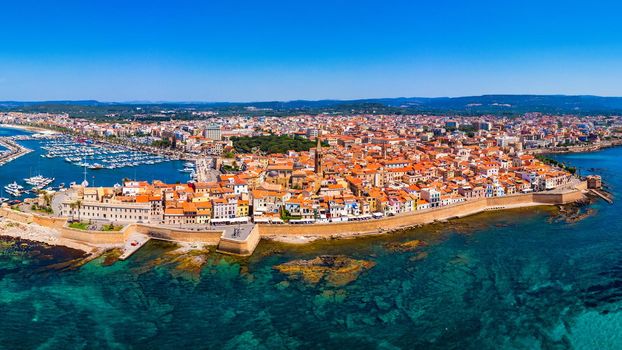 Aerial view over Alghero old town, cityscape Alghero view on a beautiful day with harbor and open sea in view. Alghero, Italy. Panoramic aerial view of Alghero, Sardinia, Italy. 