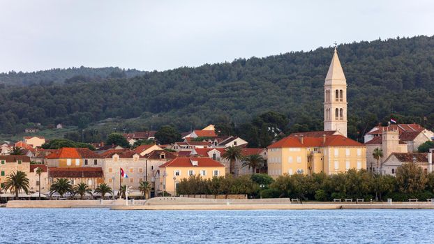 Supetar city in Brac island, Croatia. View from the sea. Picturesque scenic view on Supetar on Brac island, Croatia. Panoramic view on harbor of town Supetar from the side of sea. Brac, Croatia.