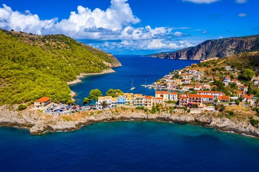 Turquoise colored bay in Mediterranean sea with beautiful colorful houses in Assos village in Kefalonia, Greece. Town of Assos with colorful houses on the mediterranean sea, Greece. 