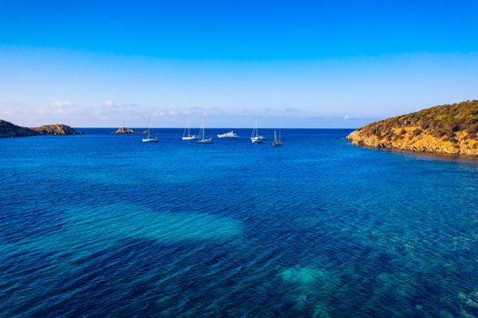 Yacht on lagoon at sunny day. Sailing boat. Yacht in the sea, aerial photography drone. Amazing yacht or sailing boat with a turquoise and transparent sea. Top view of the sailing boats in blue lagoon