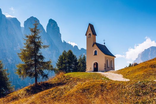 Chapel of San Maurizio at Passo Gardena, South Tyrol, Italy.  View to path to small white chapel San Maurizio and Dolomiti mountain. San Maurizio chapel on the Gardena Pass, South Tyrol, Italy.
