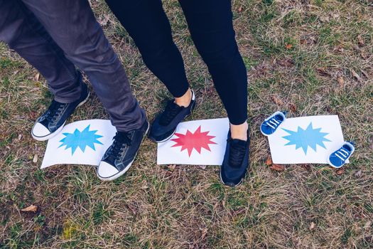 Young couple waiting for baby. Expecting parents with little baby boy shoes. Concept of Parents-To-Be. Shoes and sneakers of parents and expected baby. Mom, dad and the future baby Shoes.