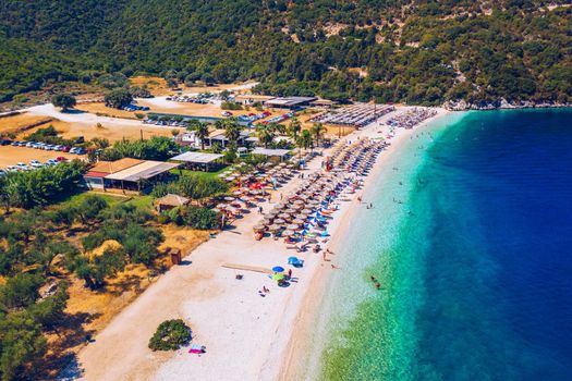 Concept of summer vacation. View from above, stunning aerial view of an amazing beach with beach umbrellas and turquoise clear water. Top view on a sun lounger under an umbrella on the sandy beach