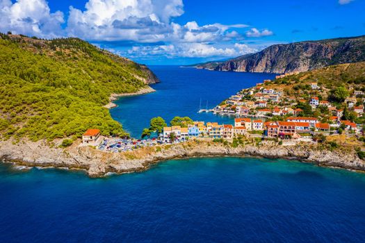 Turquoise colored bay in Mediterranean sea with beautiful colorful houses in Assos village in Kefalonia, Greece. Town of Assos with colorful houses on the mediterranean sea, Greece. 