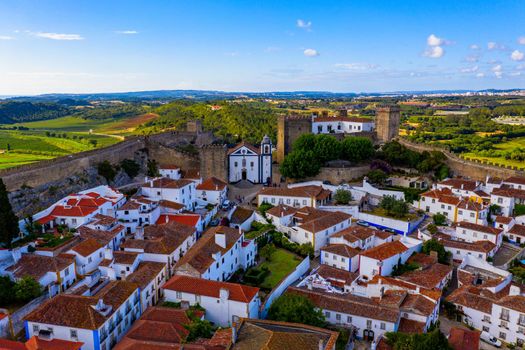 Aerial view of the historic walled town of Obidos at sunset, near Lisbon, Portugal. Aerial shot of Obidos Medieval Town, Portugal. Aerial view of medieval fortress in Obidos. Portugal.