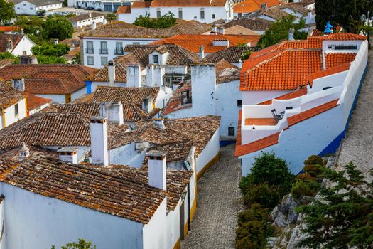 Historic walled town of Obidos, near Lisbon, Portugal. Beautiful streets of Obidos Medieval Town, Portugal. Street view of medieval fortress in Obidos. Portugal.
