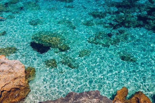 Water surface with bright sun light reflections, sea water background. Background of transparent sea water. Blue ripped sea water background.