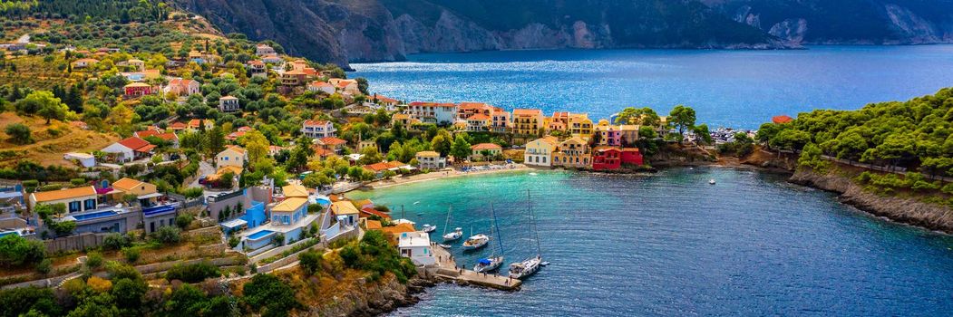 Assos village in Kefalonia, Greece. Turquoise colored bay in Mediterranean sea with beautiful colorful houses in Assos village in Kefalonia, Greece, Ionian island, Cephalonia, Assos village.