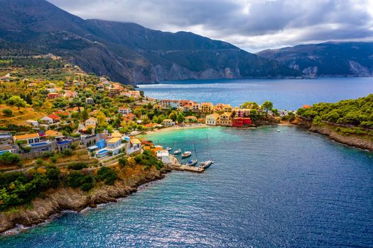 Turquoise colored bay in Mediterranean sea with beautiful colorful houses in Assos village in Kefalonia, Greece. Town of Assos with colorful houses on the mediterranean sea, Greece. 