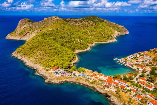 Turquoise colored bay in Mediterranean sea with beautiful colorful houses in Assos village in Kefalonia, Greece. Town of Assos with colorful houses on the mediterranean sea, Greece. 