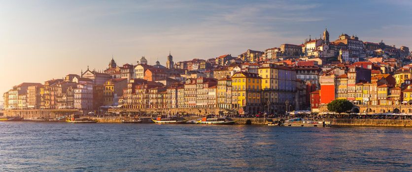Colorful houses of Porto Ribeira, traditional facades, old multi-colored houses with red roof tiles on the embankment in the city of Porto, Portugal