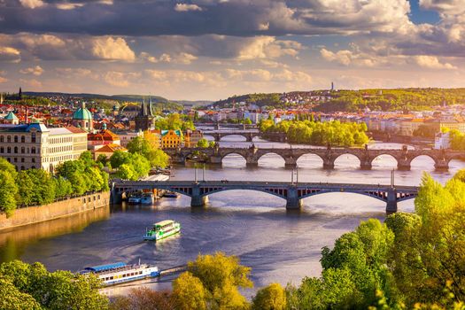 Prague red roofs and dozen spires of historical Old Town of Prague. Cityscape of Prague on a sunny day. Red rooftops, spires and the Charles Bridge and Vltava River in the background. Prague, Czechia.