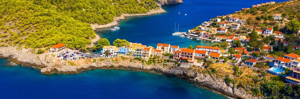 Assos village in Kefalonia, Greece. Turquoise colored bay in Mediterranean sea with beautiful colorful houses in Assos village in Kefalonia, Greece, Ionian island, Cephalonia, Assos village.