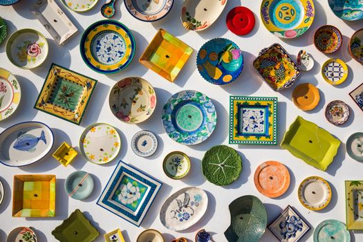 Collection of colorful Portuguese ceramic pottery, local craft products from Portugal. Ceramic plates display in Portugal. Colorful of vintage ceramic plates in Sagres, Portugal.