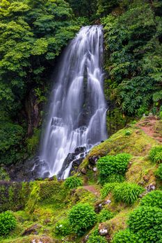 Waterfall at  Parque Natural Da Ribeira Dos Caldeiroes, Sao Miguel, Azores, Portugal. Beautiful waterfall surrounded with hydrangeas in Ribeira dos Caldeiroes park, Sao Miguel, Azores, Portugal