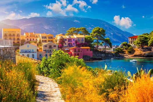 Turquoise colored bay in Mediterranean sea with beautiful colorful houses in Assos village in Kefalonia, Greece. Town of Assos with colorful houses on the mediterranean sea, Greece. 