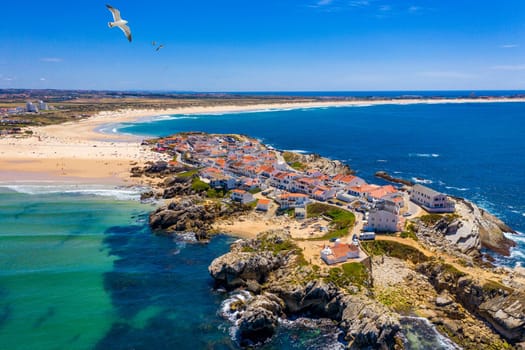 Aerial view of island Baleal naer Peniche on the shore of the ocean in west coast of Portugal. Baleal Portugal with incredible beach and surfers. Aerial view of Baleal, Portugal.