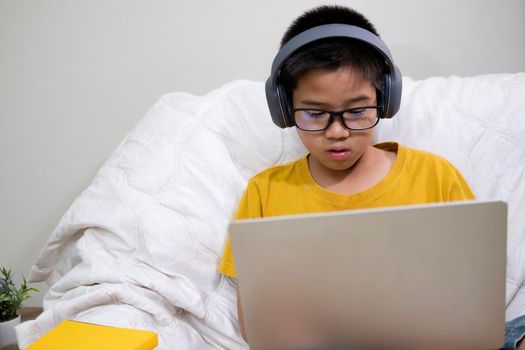 Young boy using computer and mobile device studying online. Education and online learning. 