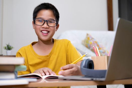 Young boy using computer and mobile device studying online. Education and online learning. 