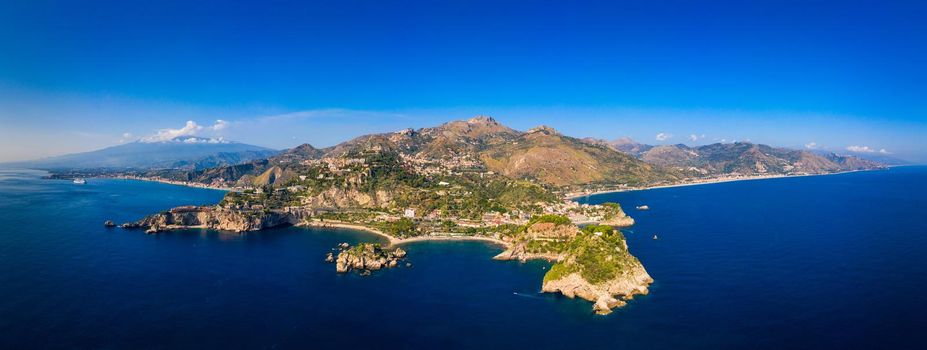 Taormina is a city on the island of Sicily, Italy. Mount Etna over Taormina cityscape, Messina, Sicily. View of Taormina located in Metropolitan City of Messina, on east coast of Sicily island, Italy.