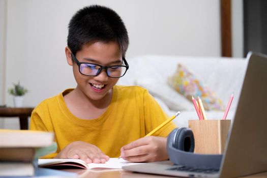 Young boy using computer and mobile device studying online. Education and online learning. 