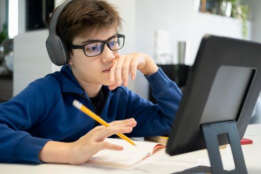 Young boy using computer and mobile device studying online. Education and online learning. 