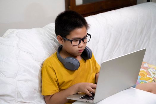 Young boy using computer and mobile device studying online. Education and online learning. 