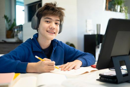 Young boy using computer and mobile device studying online. Education and online learning. 