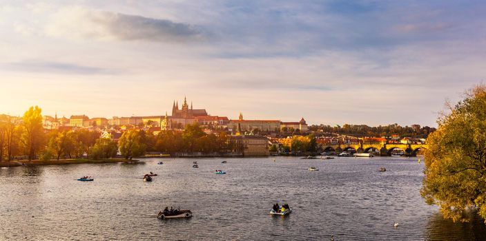 Autumn view to Charles bridge on Vltava river in Prague, Czech Republic. Autumn view to Charles Bridge, Prague old town and Vltava river. Czechia. Scenic autumn view of the Old Town with red foliage.