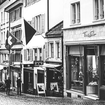 Zurich, Switzerland circa June 2021: Vintage monochrome view of historic Old Town, shops and luxury stores near main downtown Bahnhofstrasse street, Swiss architecture and travel destination