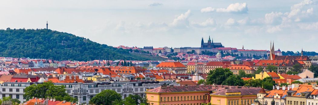 View of Prague Castle over red roof from Vysehrad area at sunset lights, Prague, Czech Republic. Scenic view of Prague city, Prague castle and Petrin tower from Vysehrad overlooking red roofs 