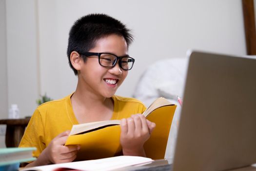 Young boy using computer and mobile device studying online. Education and online learning. 