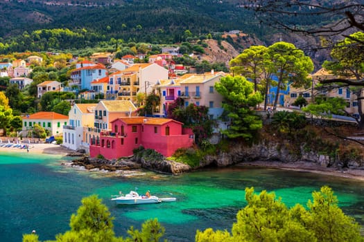 Turquoise colored bay in Mediterranean sea with beautiful colorful houses in Assos village in Kefalonia, Greece. Town of Assos with colorful houses on the mediterranean sea, Greece. 