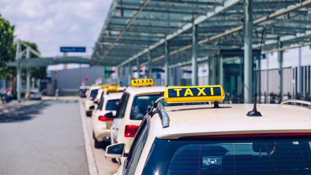 Taxi sign on the roof of a vehicle. Taxi cars on the street waiting for passengers. Selective focused image. Waiting taxi cars in the city.