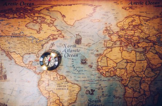 Old vintage retro golden compass on ancient map. Selective focus, shallow depth of field. Concept of world travel, sightseeing and tourism.