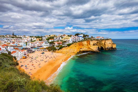 View of Carvoeiro fishing village with beautiful beach, Algarve, Portugal. View of beach in Carvoeiro town with colorful houses on coast of Portugal. The village Carvoeiro in the Algarve Portugal.